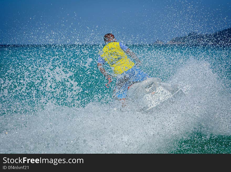 Man in Yellow Shirt Using Personal Watercraft