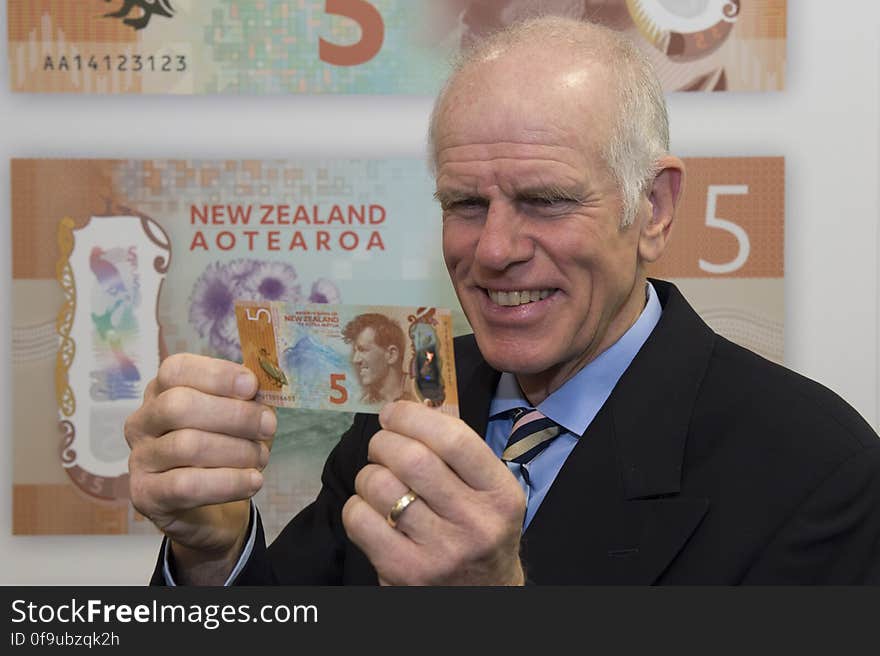 Peter Hillary holding the new $5 note featuring Sir Edmund Hillary