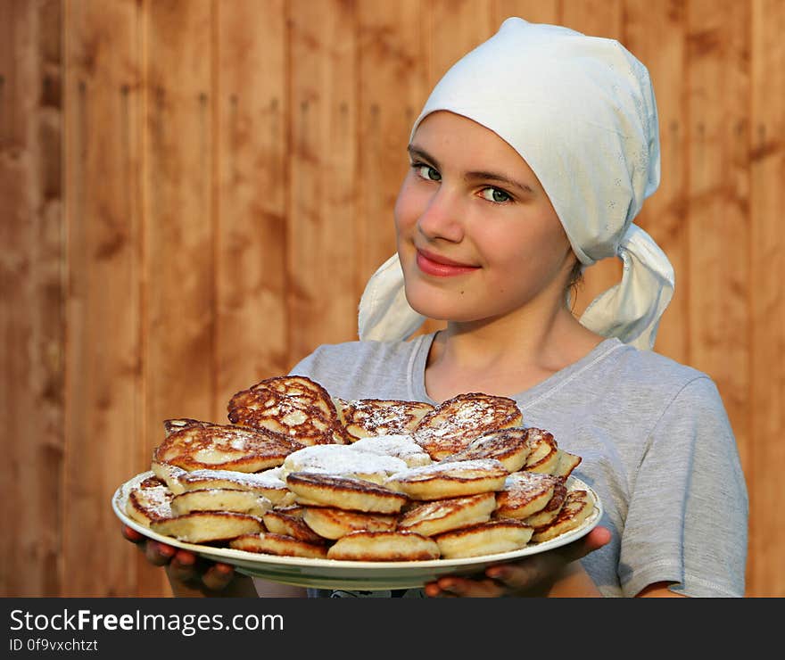 Woman in Grey Crew Neck Shirt Holding a White Ceramic Plate With Pancakes