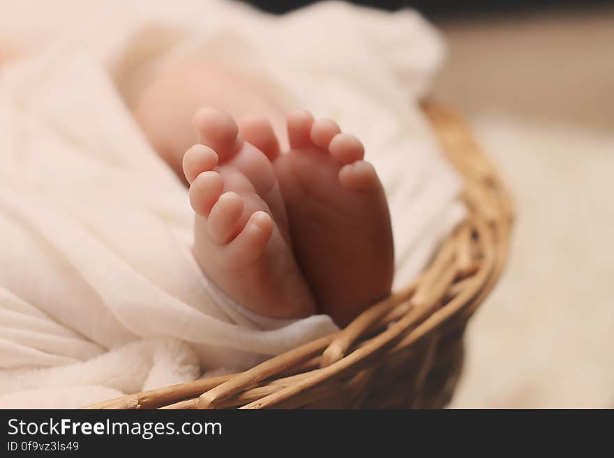 Baby&#x27;s Feet on Brown Wicker Basket