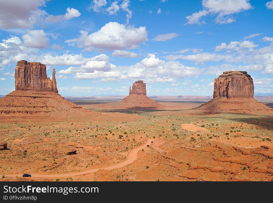 Brown Rock Formation Under White and Blue Cloudy Sky