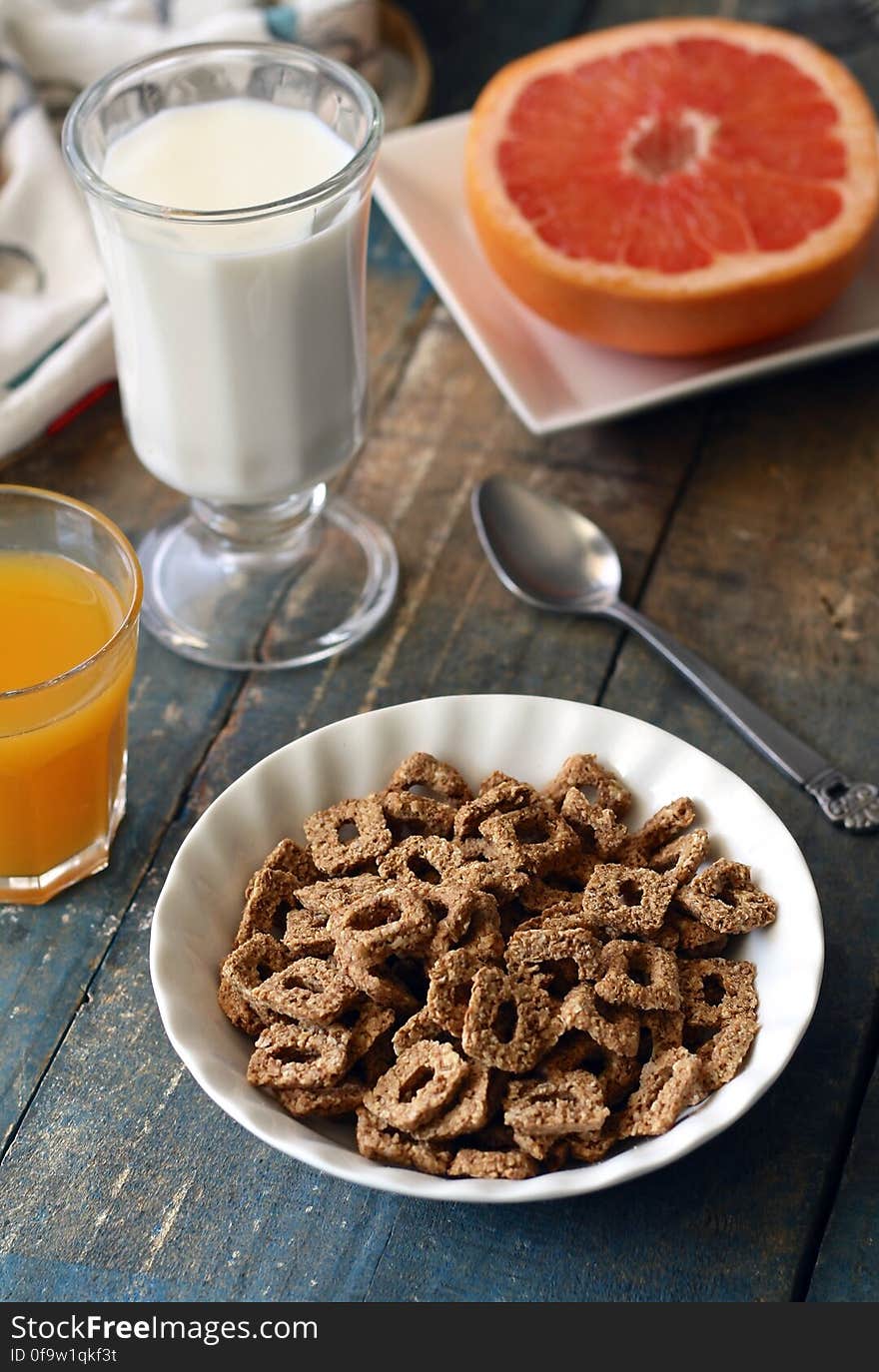 Chocolate Cereal on White Bowl Near Glass of Milk