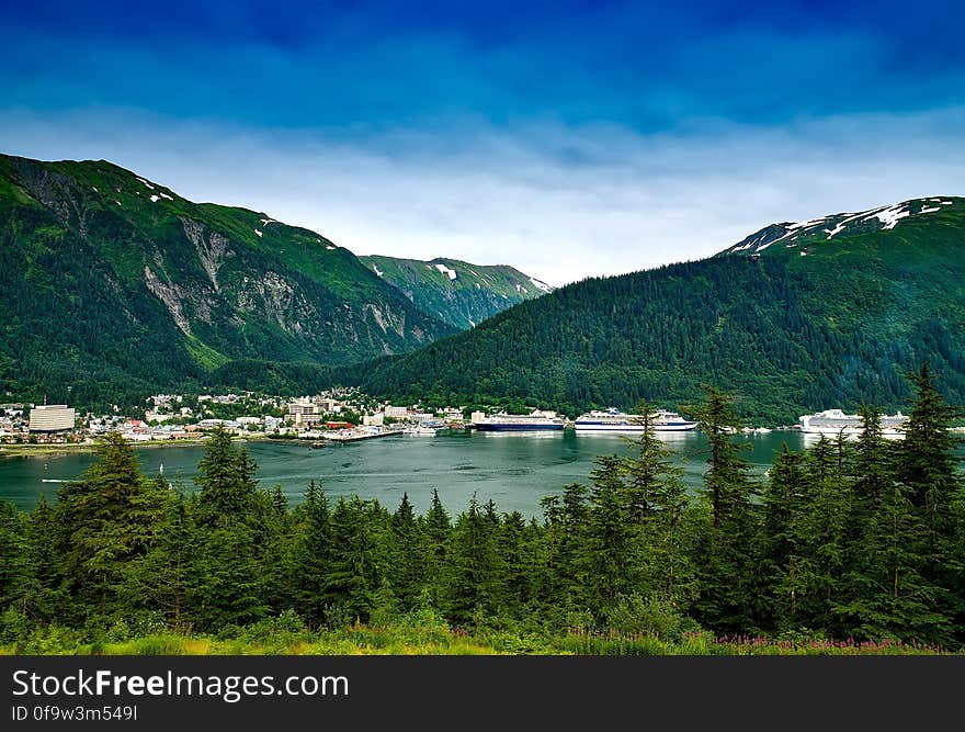 Blue Lake Surrounded by Mountains and Green Leaved Trees during Daytime