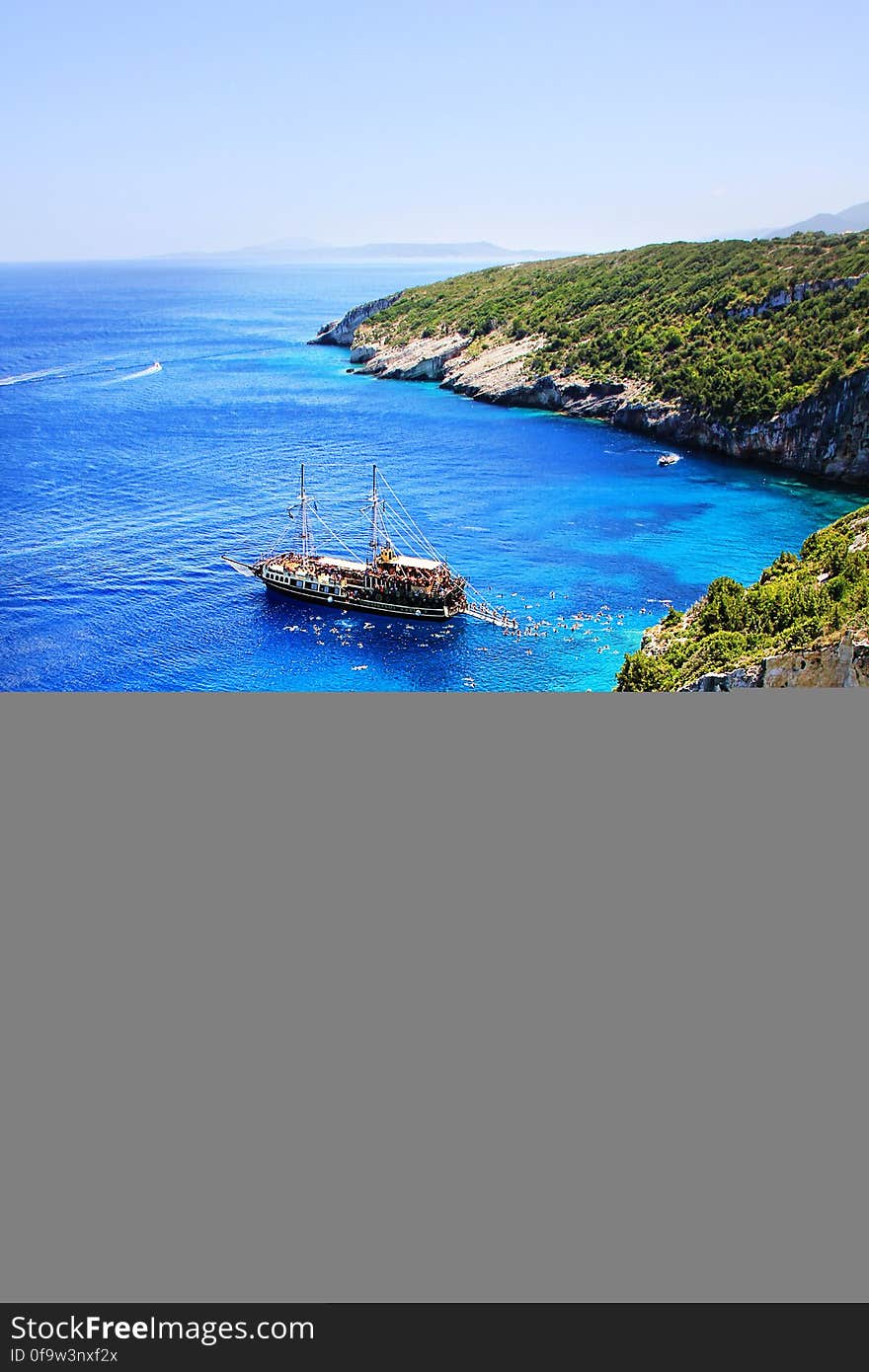 Brown and White Boat on Blue Seashore