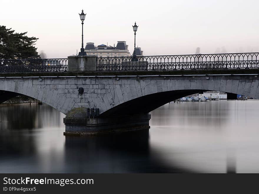 Grey Bridge With Light Post Under White Sky during Daytime