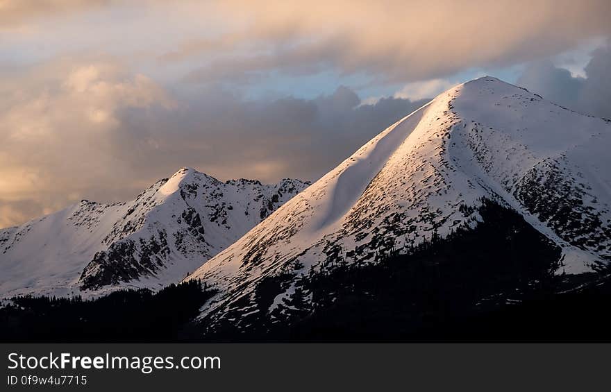 Mountain With Snow Under Cloudy Skies