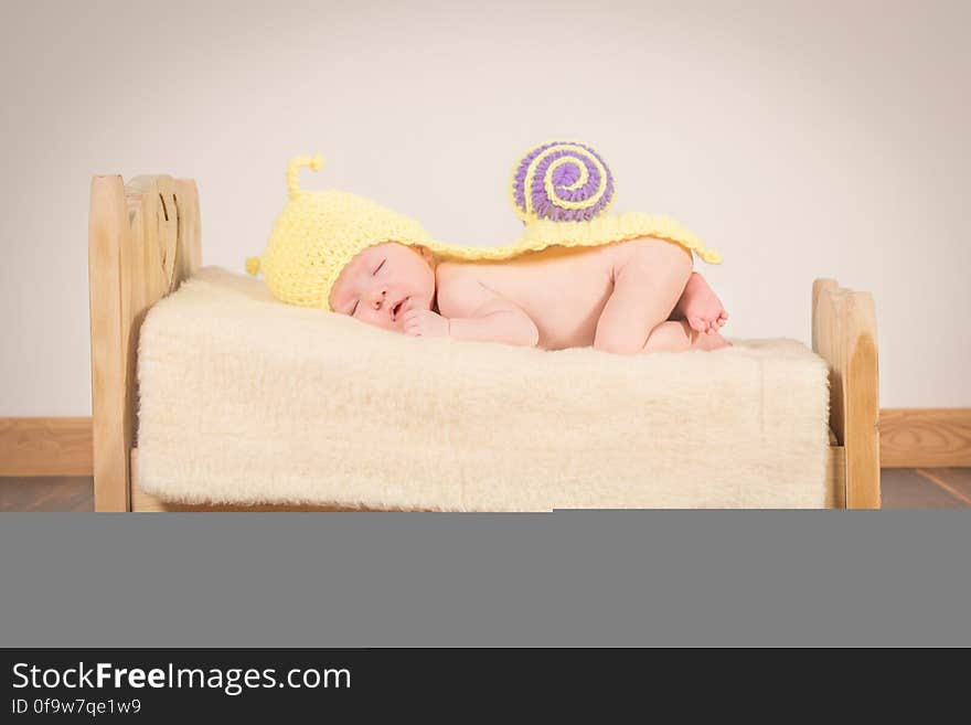 A baby on tiny bed with snail costume. A baby on tiny bed with snail costume.