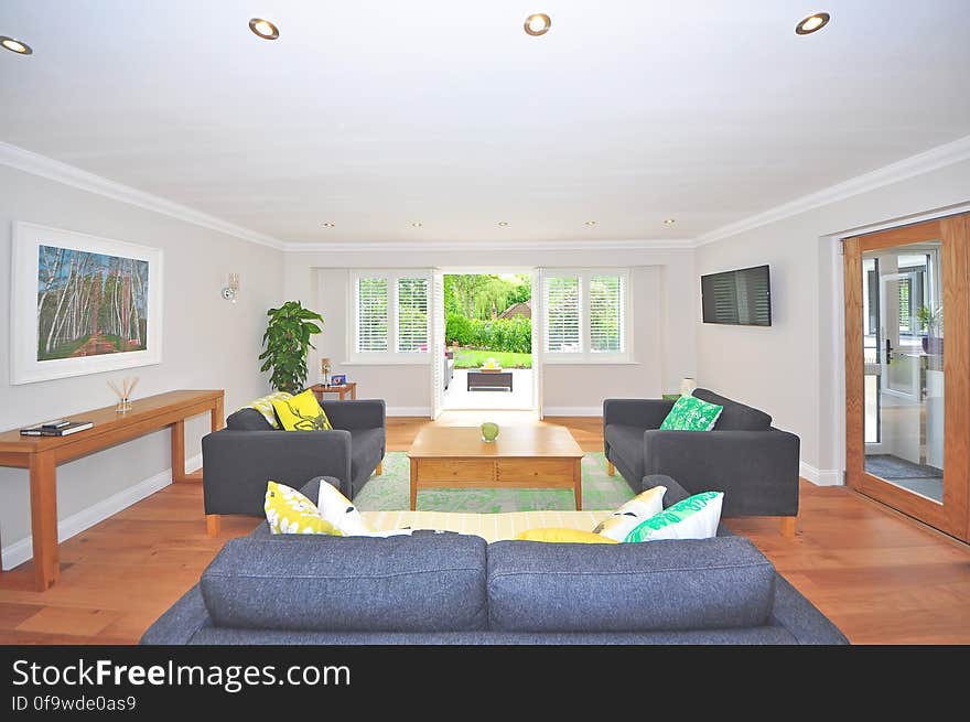 Brown Wooden Coffee Table Near Black Sofa Near the Window