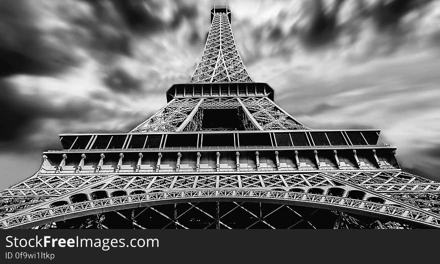 Black and white facade of Eiffel Tower in Paris, France from below with cloudy skies. Black and white facade of Eiffel Tower in Paris, France from below with cloudy skies.