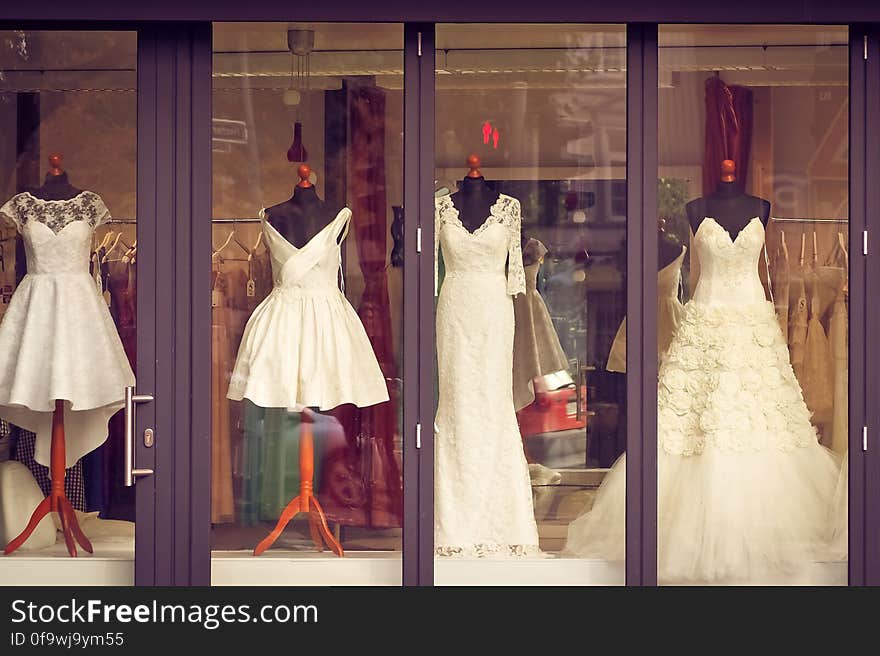 Display of white long and short bridal gowns in window of store. Display of white long and short bridal gowns in window of store.