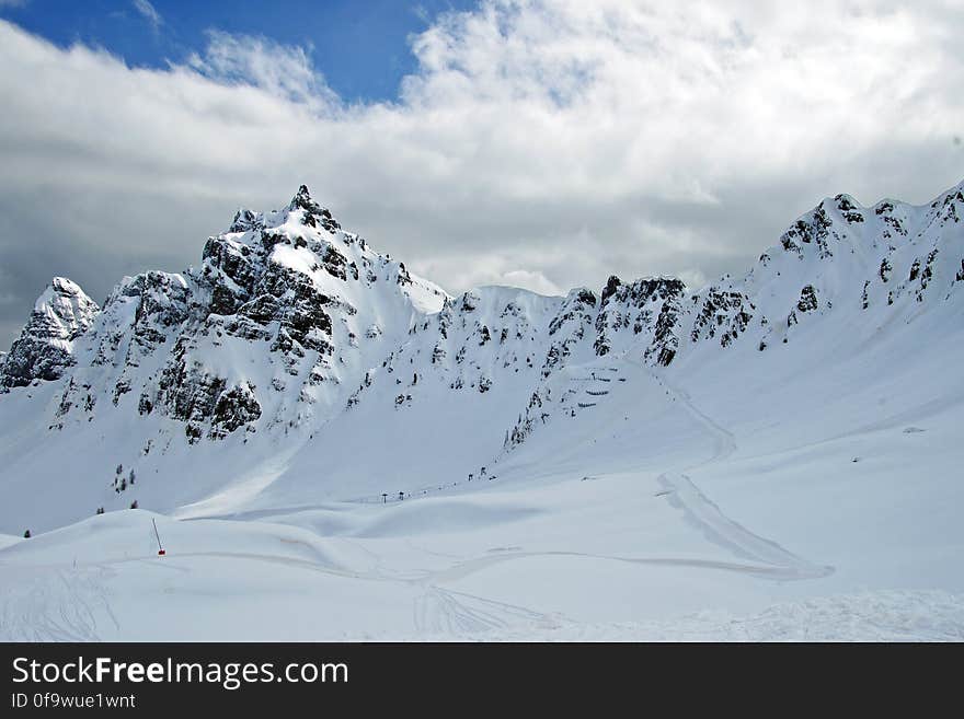 Skiers performing extreme skiing on steep rocky slopes of the Alps. Skiers performing extreme skiing on steep rocky slopes of the Alps.