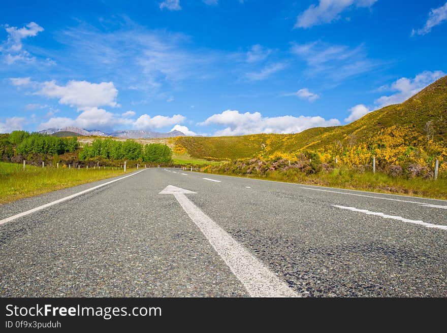 Road Passing Through Landscape Against Blue Sky