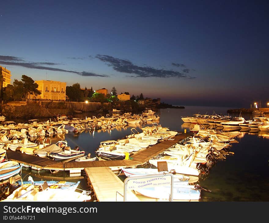 Porto Ulisse Ognina Catania Sicily Il porto Ulisse Ã¨ il porticciolo di Ognina, borgata periferica della cittÃ  di Catania, posto alle coordinate 37Â° 31&#x27;,53 Nord e 15Â° 07&#x27;,27 Est. Il porto Ulisse si trova sulla costa nord della cittÃ  di Catania ricavato da un&#x27;insenatura nella scogliera rocciosa; era un approdo portuale di Catania sin dall&#x27;antichitÃ . Nell&#x27;area ove sorge il porto attuale sfociava un fiume il Lognina od Ognina che venne seppellito da una colata lavica dell&#x27;Etna in epoca medioevale. Nel 1381 il borgo di Ognina venne interamente sepolto da una colata di lava e dell&#x27;approdo rimase solo una piccola insenatura, quella attuale. Nel porto era presente anche una fiorente attivitÃ  cantieristica i cui mastri d&#x27;ascia erano conosciuti ed apprezzati. Da porto da pesca nel dopoguerra si Ã¨ lentamente attrezzato come porto turistico ed oggi offre servizi ed assistenza specializzati. Il porto si trova circa 3 miglia a nord-est del Porto di Catania ed Ã¨ protetto da un molo foraneo di oltre 150 m con faro rosso di segnalazione sulla testata, un molo interno piÃ¹ piccolo e vari pontili galleggianti. I fondali vanno da 1,5 a 12 metri di profonditÃ  e sono fangosi nella parte piÃ¹ interna e rocciosi verso l&#x27;esterno. Il porto Ã¨ attrezzato con rifornimento di carburante ed acqua, cantieri navali e quattro gru di alaggio. Vi hanno sede diversi Club nautici. ognina catania boat fisher island isola sicilia sicily italia italy sea sun landscape europe wallpaper castielli travel creativecommons creative commons zero CC0 cc0 CC cc panoramio flickr googleearth maps geotagged gimp wikimedia. Porto Ulisse Ognina Catania Sicily Il porto Ulisse Ã¨ il porticciolo di Ognina, borgata periferica della cittÃ  di Catania, posto alle coordinate 37Â° 31&#x27;,53 Nord e 15Â° 07&#x27;,27 Est. Il porto Ulisse si trova sulla costa nord della cittÃ  di Catania ricavato da un&#x27;insenatura nella scogliera rocciosa; era un approdo portuale di Catania sin dall&#x27;antichitÃ . Nell&#x27;area ove sorge il porto attuale sfociava un fiume il Lognina od Ognina che venne seppellito da una colata lavica dell&#x27;Etna in epoca medioevale. Nel 1381 il borgo di Ognina venne interamente sepolto da una colata di lava e dell&#x27;approdo rimase solo una piccola insenatura, quella attuale. Nel porto era presente anche una fiorente attivitÃ  cantieristica i cui mastri d&#x27;ascia erano conosciuti ed apprezzati. Da porto da pesca nel dopoguerra si Ã¨ lentamente attrezzato come porto turistico ed oggi offre servizi ed assistenza specializzati. Il porto si trova circa 3 miglia a nord-est del Porto di Catania ed Ã¨ protetto da un molo foraneo di oltre 150 m con faro rosso di segnalazione sulla testata, un molo interno piÃ¹ piccolo e vari pontili galleggianti. I fondali vanno da 1,5 a 12 metri di profonditÃ  e sono fangosi nella parte piÃ¹ interna e rocciosi verso l&#x27;esterno. Il porto Ã¨ attrezzato con rifornimento di carburante ed acqua, cantieri navali e quattro gru di alaggio. Vi hanno sede diversi Club nautici. ognina catania boat fisher island isola sicilia sicily italia italy sea sun landscape europe wallpaper castielli travel creativecommons creative commons zero CC0 cc0 CC cc panoramio flickr googleearth maps geotagged gimp wikimedia