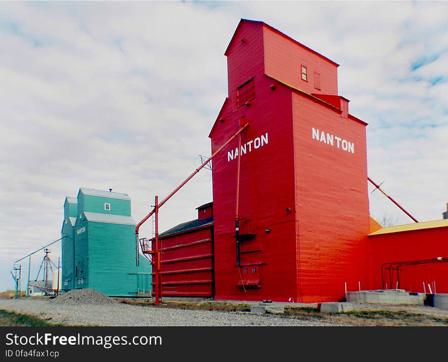 In 2001 the last of Nanton’s grain elevator row was threatened by demolition because of recent abandonment of the Canadian Pacific Railway that the elevators stood next to. Many worried citizens in and around the town of Nanton had realized that a part of the town&#x27;s and province&#x27;s history was about to be torn down and lost forever. The concerned citizens of Nanton had rallied together and formed a Historical Society appropriately named &#x22;Save One&#x22;. Of course the original goal of the save one effort was to do just that, save one, but before anything could be done to save the elevator the Society had to gain full title to the land and buildings. Which was a big undertaking that would take three years to achieve. With so many volunteer hours from many local businesses and citizens, the Society was so successful that not only did they end up saving just one elevator, but all three remaining elevators. Many donations from members and surrounding farmers-ranchers, have been made and have helped in replacing the railway tracks next to the elevators the completion of many of the repairs and restorations that needed to be done on the elevators. Including painting the former Alberta Wheat Pool back to its original green and the former Pioneer elevator back to the original orange & yellow. In 2001 the last of Nanton’s grain elevator row was threatened by demolition because of recent abandonment of the Canadian Pacific Railway that the elevators stood next to. Many worried citizens in and around the town of Nanton had realized that a part of the town&#x27;s and province&#x27;s history was about to be torn down and lost forever. The concerned citizens of Nanton had rallied together and formed a Historical Society appropriately named &#x22;Save One&#x22;. Of course the original goal of the save one effort was to do just that, save one, but before anything could be done to save the elevator the Society had to gain full title to the land and buildings. Which was a big undertaking that would take three years to achieve. With so many volunteer hours from many local businesses and citizens, the Society was so successful that not only did they end up saving just one elevator, but all three remaining elevators. Many donations from members and surrounding farmers-ranchers, have been made and have helped in replacing the railway tracks next to the elevators the completion of many of the repairs and restorations that needed to be done on the elevators. Including painting the former Alberta Wheat Pool back to its original green and the former Pioneer elevator back to the original orange & yellow.