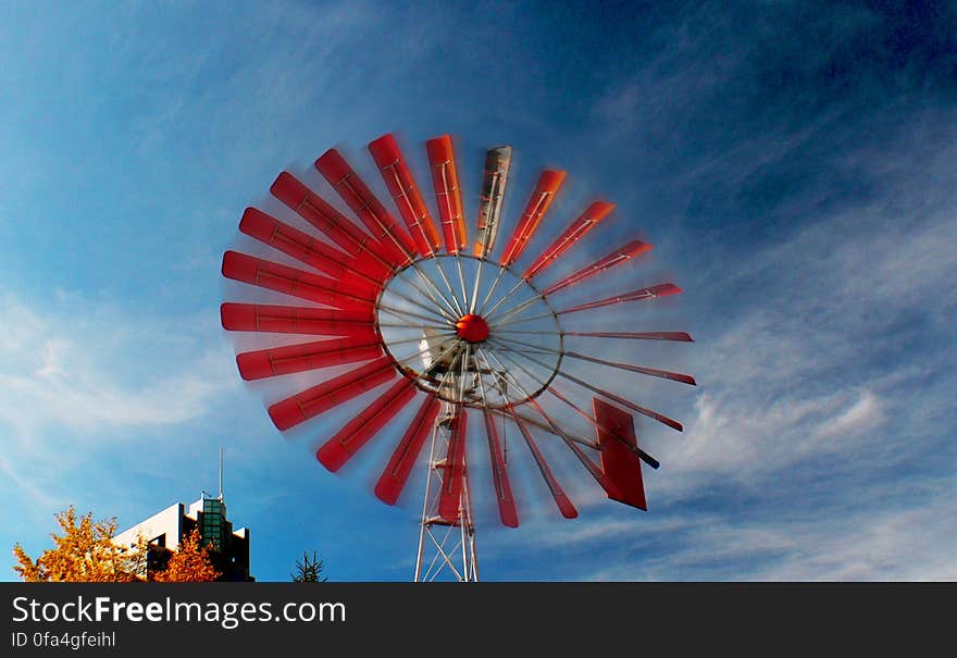 This windmill is located in the Eau Clair shopping area, near the wading pool and Prince&#x27;s Island Park in Calgary, Alberta. A windmill is a machine that converts the energy of wind into rotational energy by means of vanes called sails. Originally, windmills were developed for milling grain for food production. In the course of history, the windmill machinery was adapted to many other industrial uses. An important non-milling use is to pump water, either for land drainage or to extract groundwater. This windmill is located in the Eau Clair shopping area, near the wading pool and Prince&#x27;s Island Park in Calgary, Alberta. A windmill is a machine that converts the energy of wind into rotational energy by means of vanes called sails. Originally, windmills were developed for milling grain for food production. In the course of history, the windmill machinery was adapted to many other industrial uses. An important non-milling use is to pump water, either for land drainage or to extract groundwater.