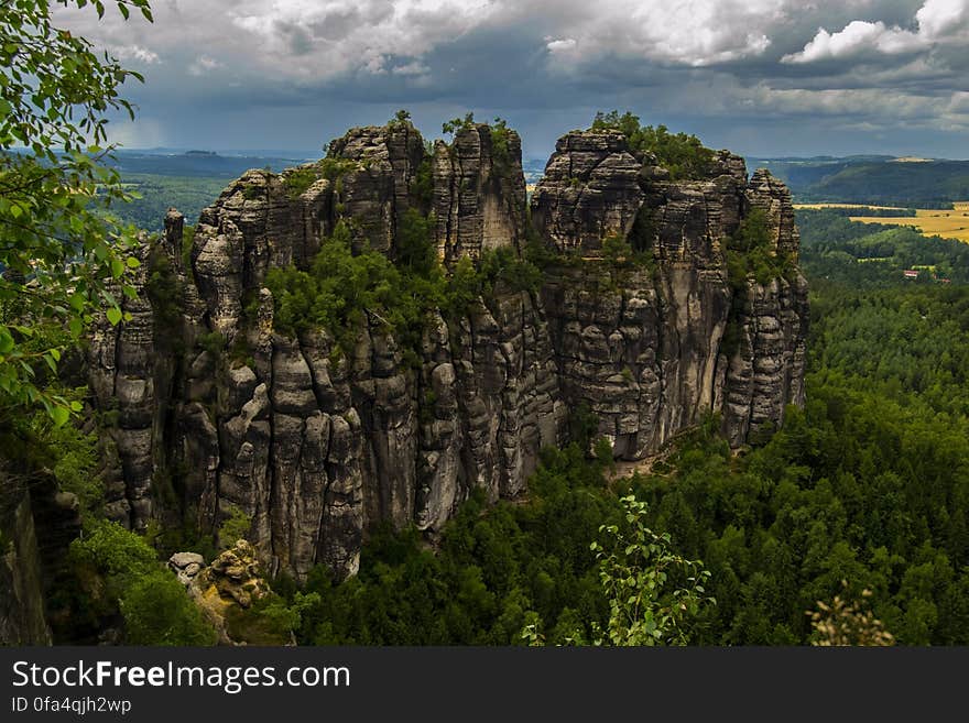 Rock Formation Surrounded by Green Trees during Humid Weather