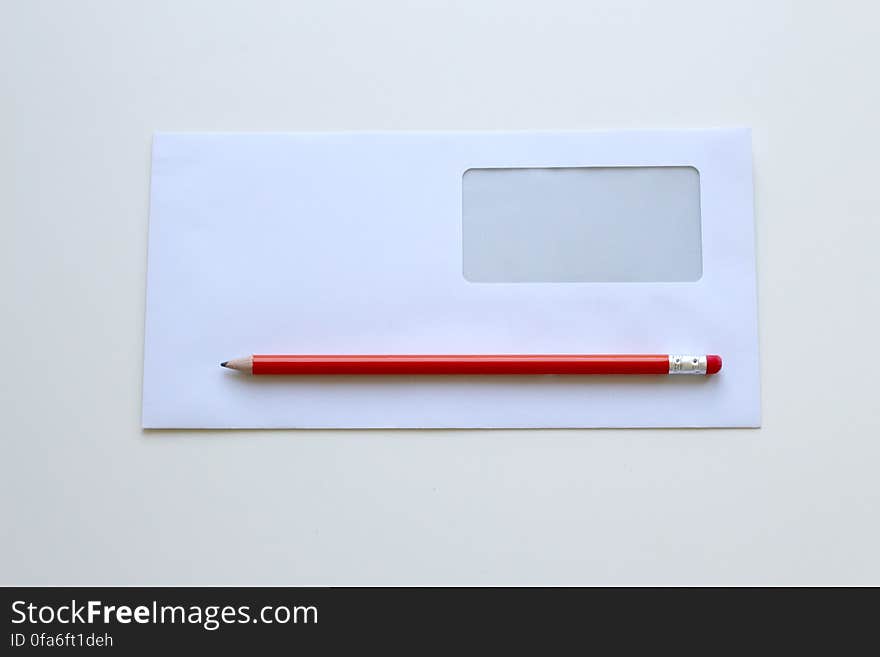 Envelope with address window, sheet of blank paper and red pencil with rubber on the end. Envelope with address window, sheet of blank paper and red pencil with rubber on the end.