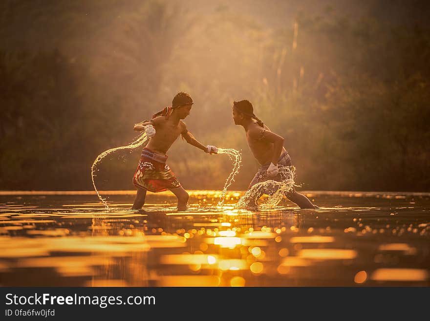 Young boys splashing and playing in water at dawn. Young boys splashing and playing in water at dawn.