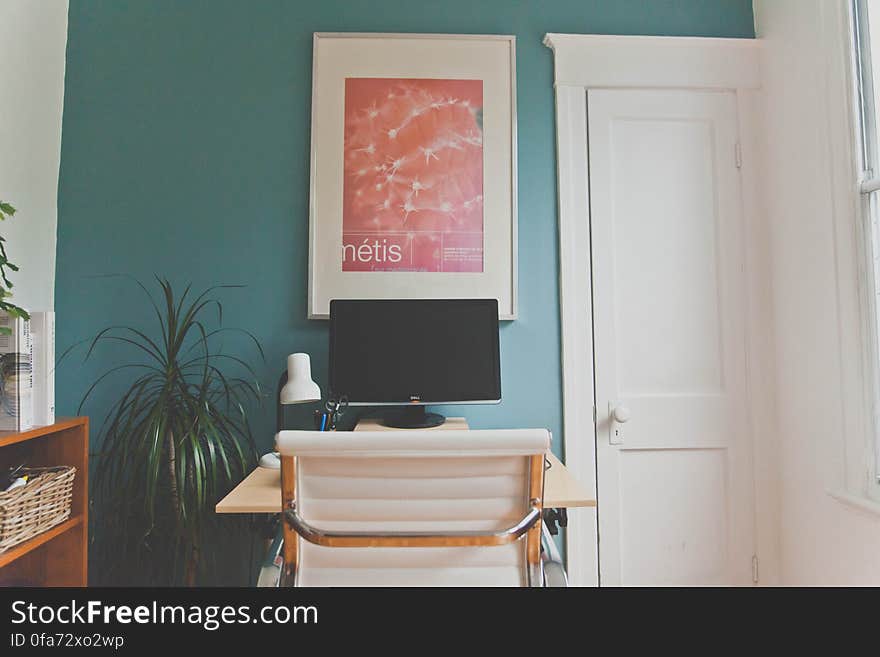 Desk with white chair holding computer inside home office. Desk with white chair holding computer inside home office.