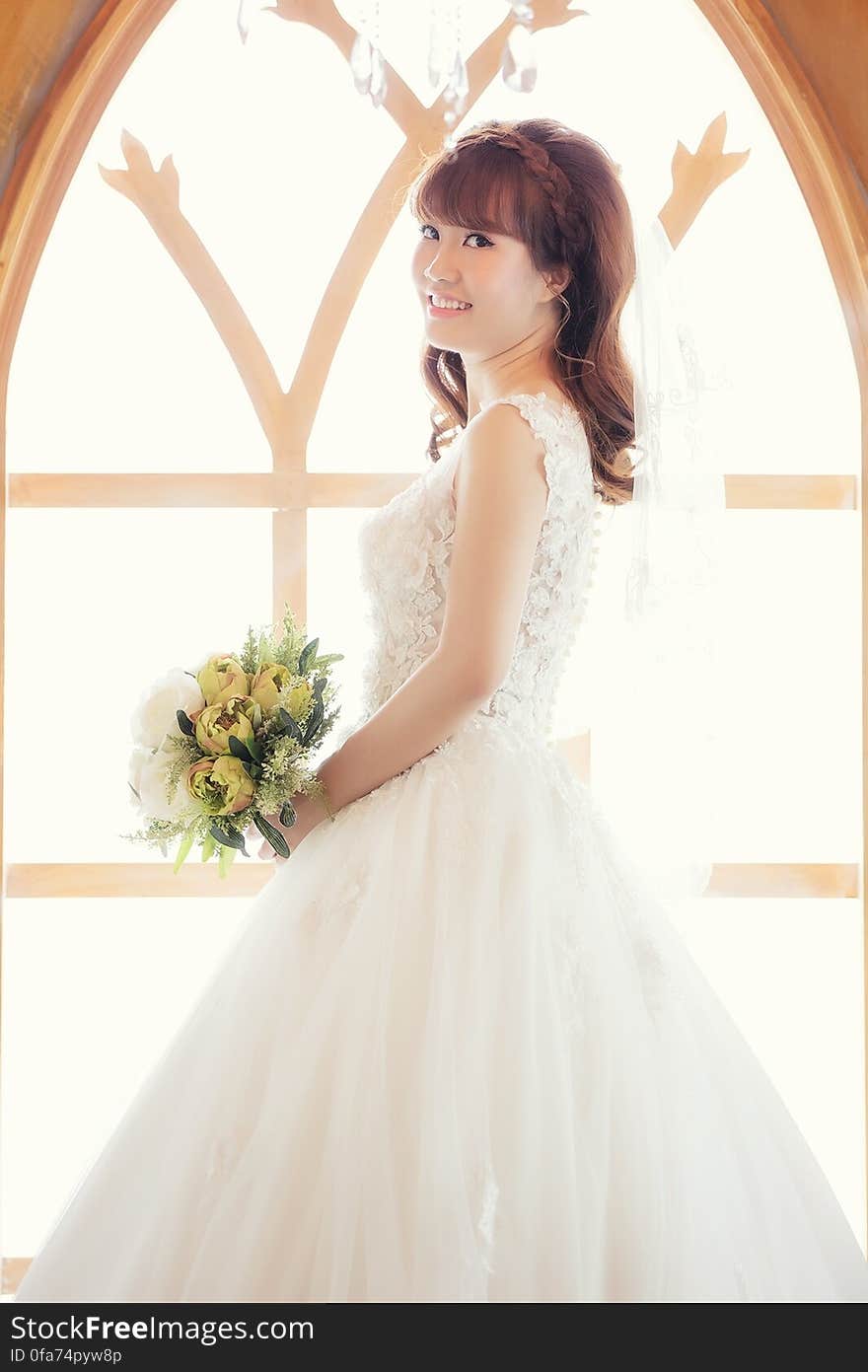 Portrait of bride in wedding gown holding bouquet smiling in church. Portrait of bride in wedding gown holding bouquet smiling in church.