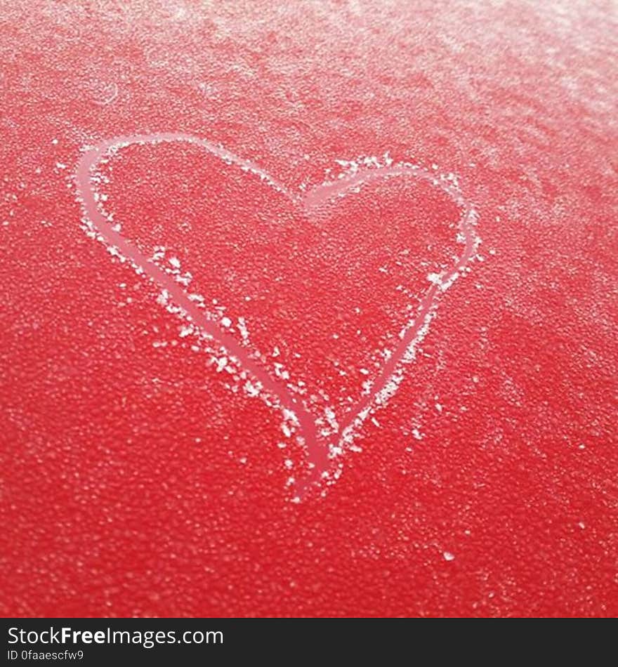 Heart etched in the frost on top of my red car. Heart etched in the frost on top of my red car