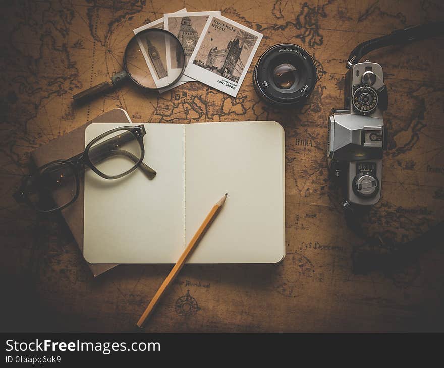 A still life with a notebook, camera and a retro map. A still life with a notebook, camera and a retro map.