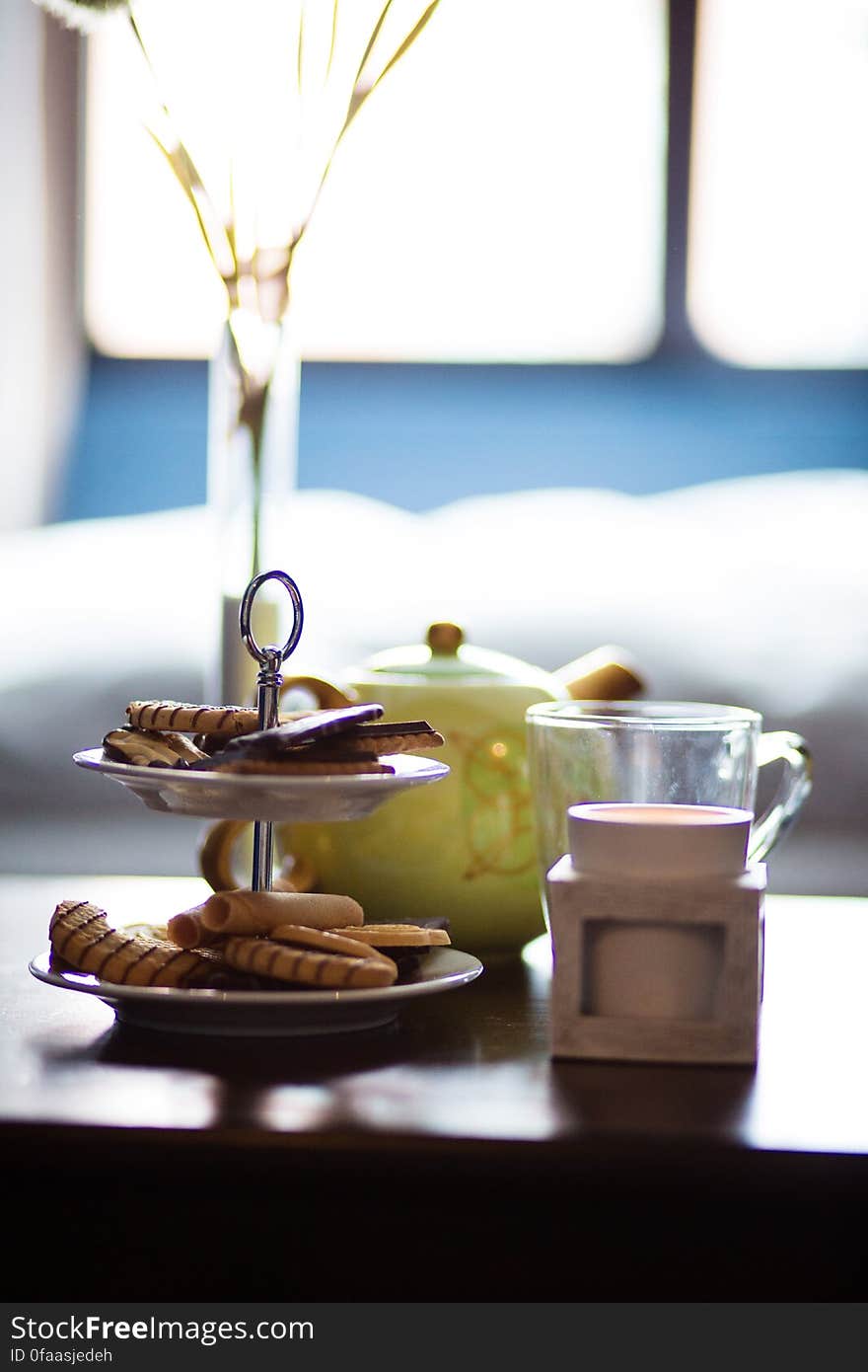 A coffee table set with cookies and tea pot. A coffee table set with cookies and tea pot.