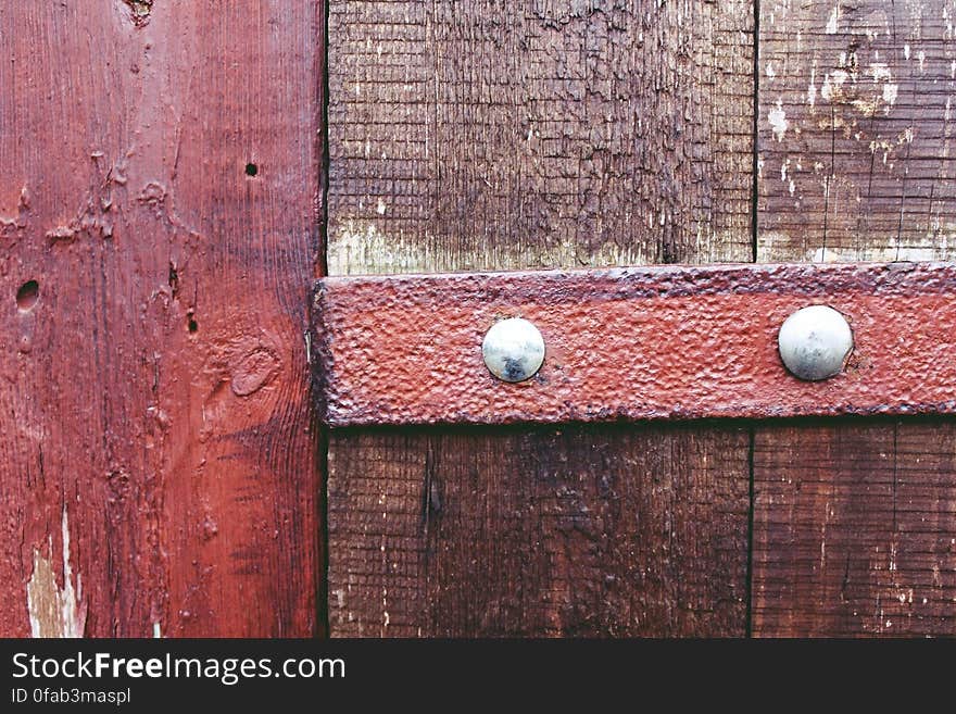 A close up of an old wooden door with a rusty steel detail.