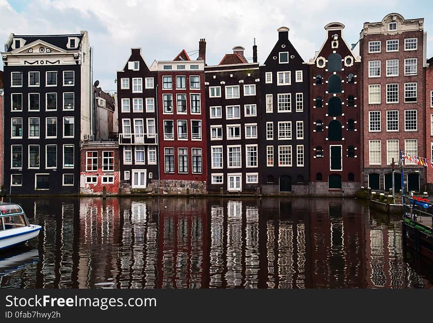 Tall historic buildings in European city reflecting on canal. Tall historic buildings in European city reflecting on canal.