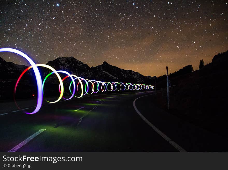 A road with light trails under the starry skies. A road with light trails under the starry skies.