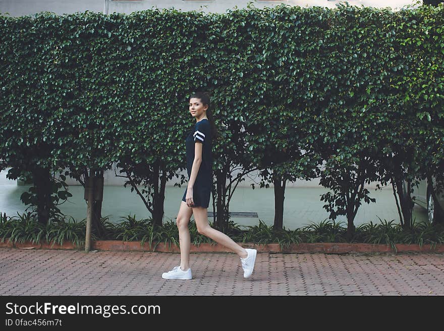 Woman Standing by Tree in the Street