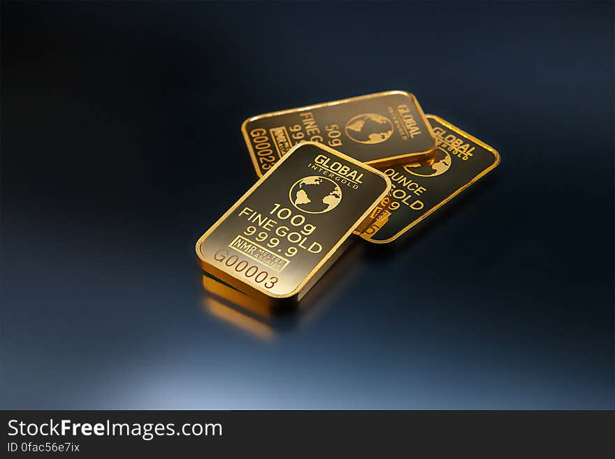 Three Gold Bars Against Dark Background