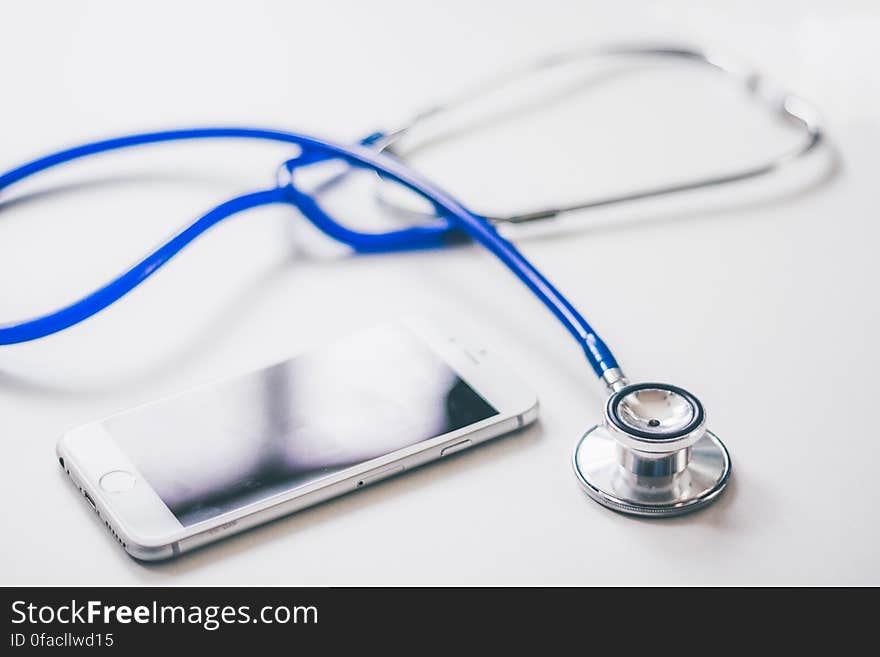 Silver Iphone 6 Near Blue and Silver Stethoscope