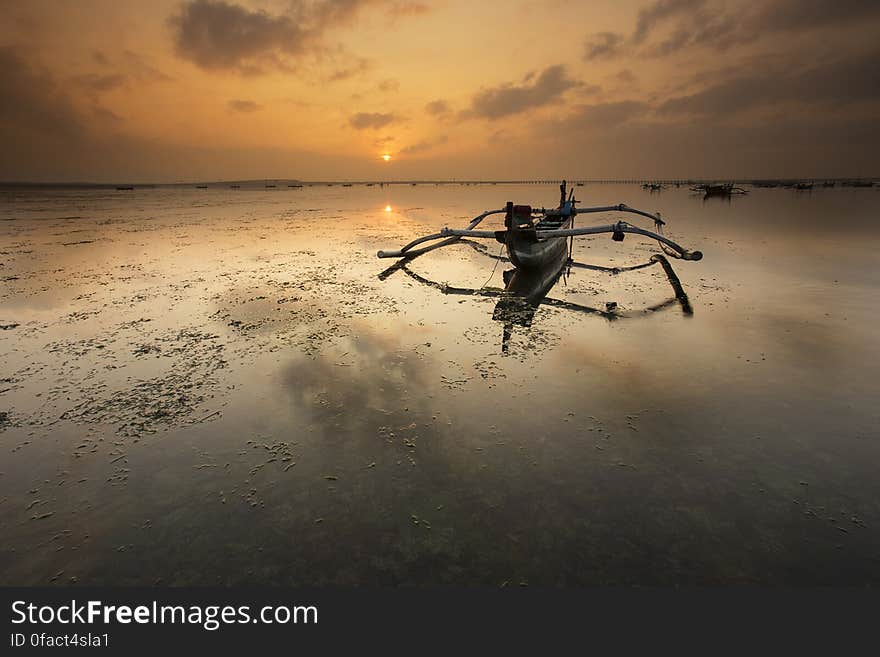 Brown Canoe Docked on Sea