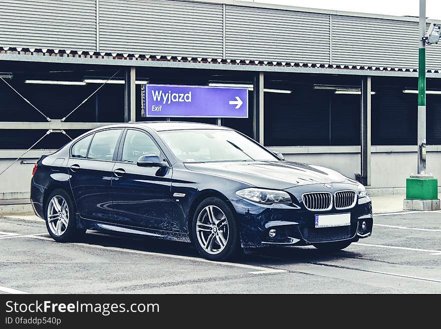 Black luxury BMW sedan parked in lot on sunny day. Black luxury BMW sedan parked in lot on sunny day.