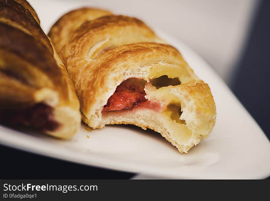 Close up of puff pastry dessert with bite taken on white china plate.