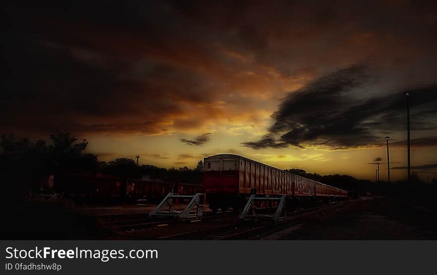 Red and White Train Taken during Sunset