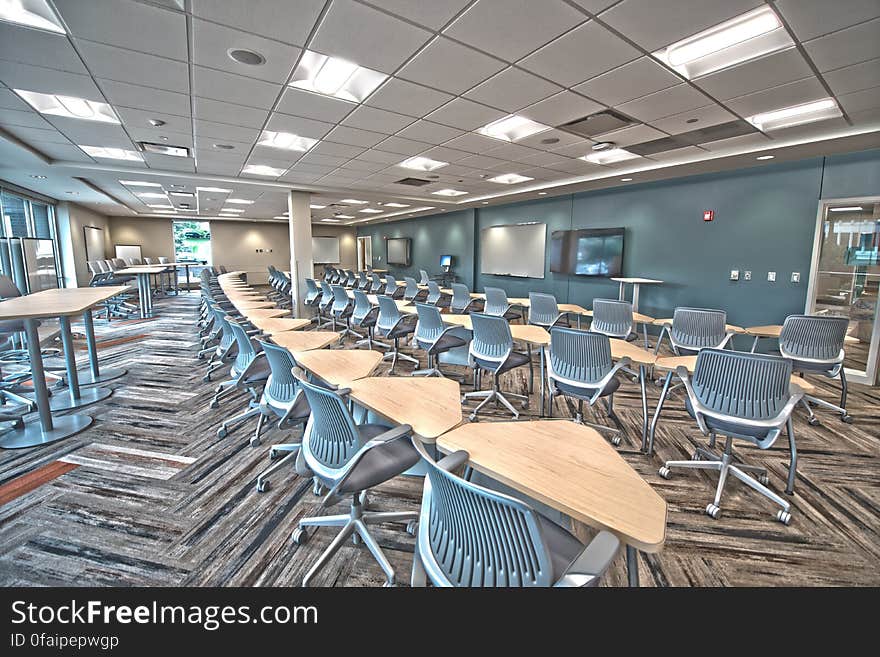 Brown Wooden Triangular Tables and Gray Rolling Chairs Inside Room