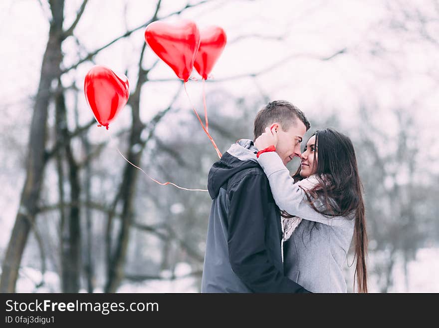 Two People With Heart Shape Balloons in Winter