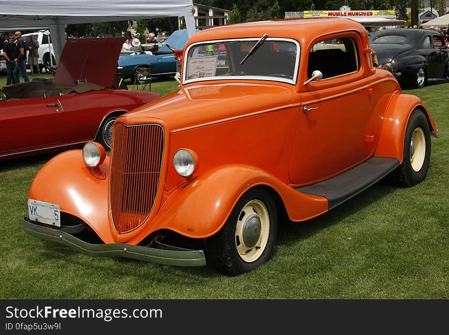 Orange Classic Coupe on Green Grass Field