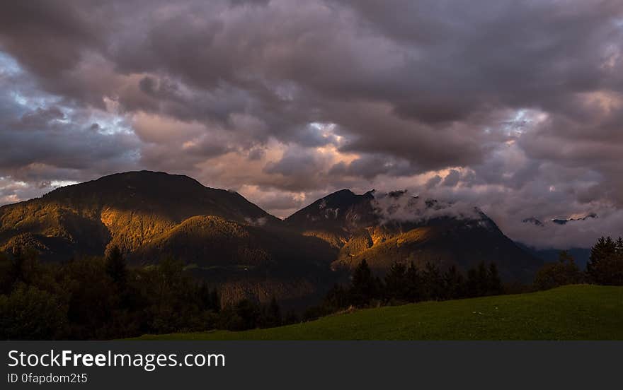 Dawn breaking through clouds over mountain peaks. Dawn breaking through clouds over mountain peaks.