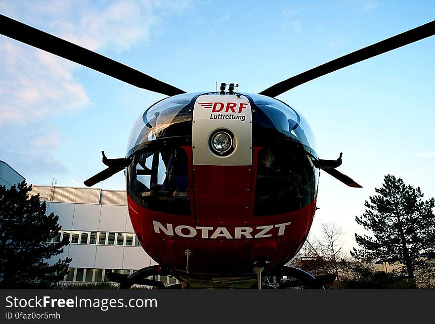 Helicopter parked on lawn outside hospital building on sunny day. Helicopter parked on lawn outside hospital building on sunny day.