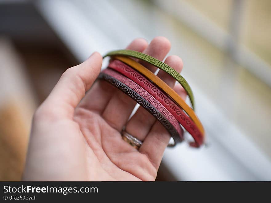 Close-up of Human Hand Holding Multi Colored Bracelets