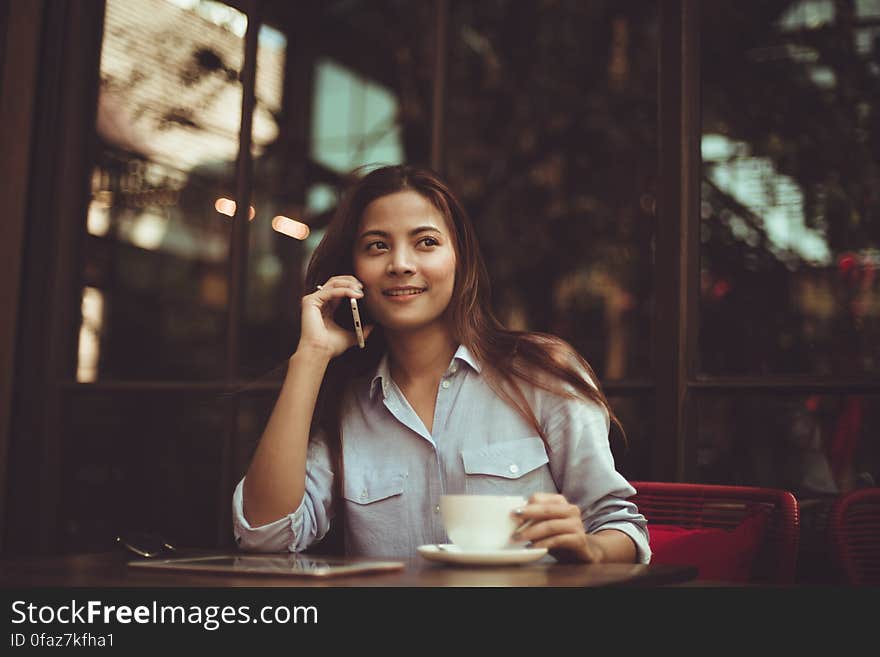 Portrait of Young Woman Using Mobile Phone in Cafe