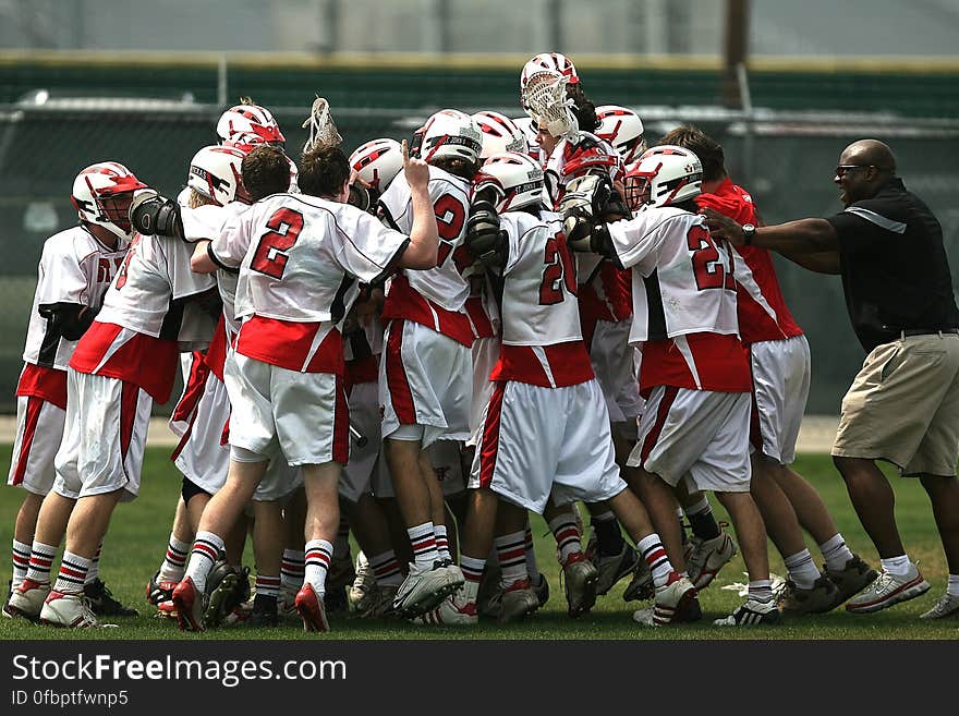 Group of Football Player Celebrating With Coach during Daytime