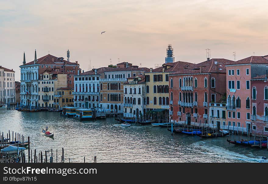 Boat Sailing on Canal Near Buildings during Day Time