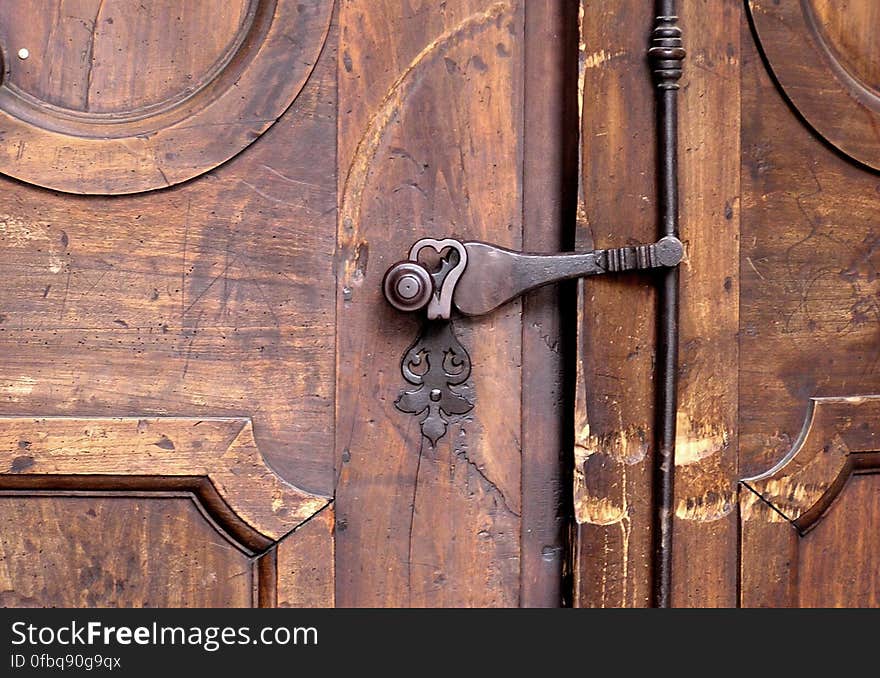 Close up of antique brass door knob and handle on rustic wooden door. Close up of antique brass door knob and handle on rustic wooden door.