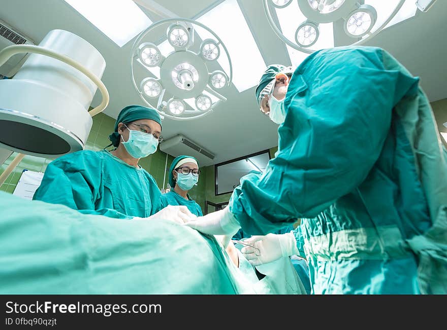 Surgeons working on table inside modern operating theater. Surgeons working on table inside modern operating theater.