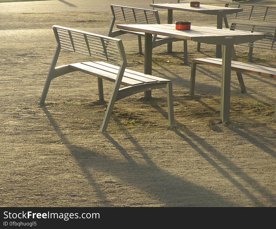 Ashtrays on empty tables and chairs on grassy lawn in sunshine. Ashtrays on empty tables and chairs on grassy lawn in sunshine.