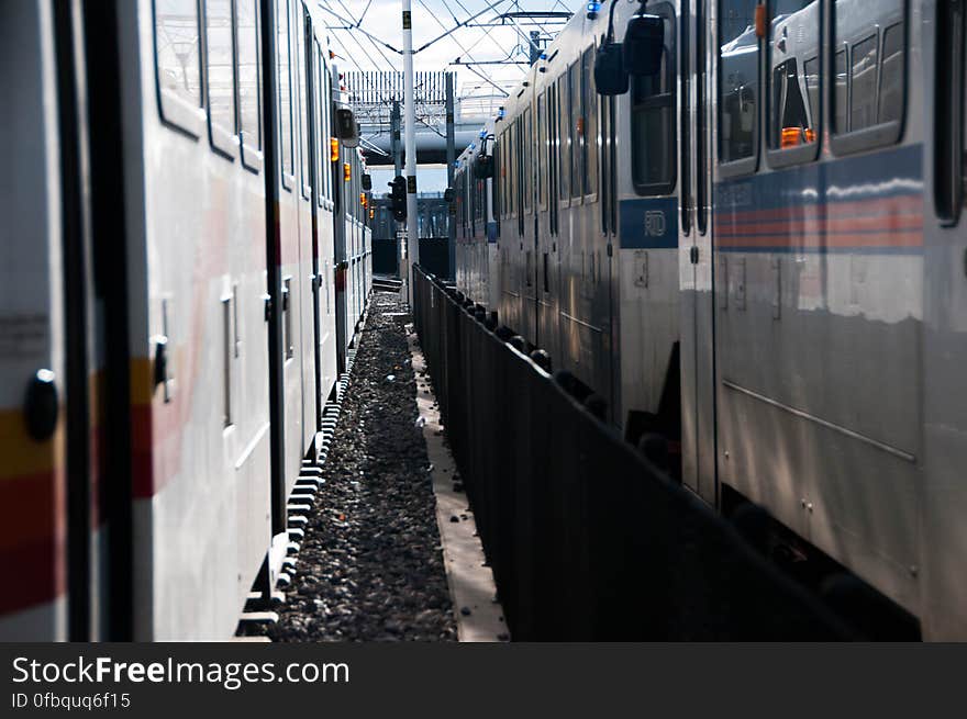 Train compartments parked side by side on railroad tracks on sunny day. Train compartments parked side by side on railroad tracks on sunny day.